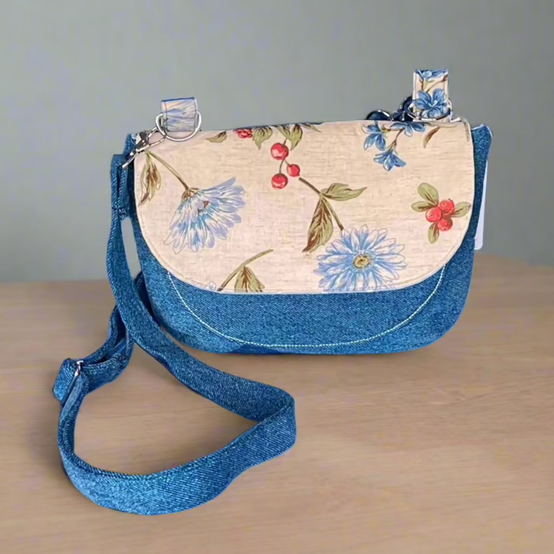 Bright blue reclaimed denim, blue flowers and red berries on cream background flap with magnetic clasp. Crossbody purse.